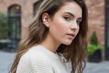 Load image into Gallery viewer, Woman with long brown hair wearing a white sweater outdoors. Ear cuff with heart dangle is the featured jewelry