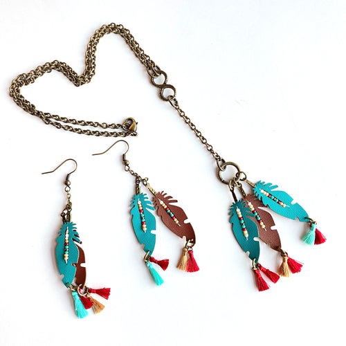 Brass Infinity Necklace with Leather Feather Dangles in Turquoise and Tan, seed beads and tassels in reds, gold and turquoise. Combine with Leather Feather Earrings of same descript.   Collection: Leather Color: Turquoise, tan, red and white Drop Length: Necklace 17 inch - Earrings 3 1/4 inch Materials: Leather, glass beads Metals: Brass