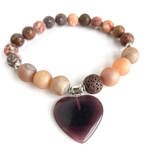 Rusts, Browns, Creams, and Champagne meld into a stunning diffuser bracelet with a  brown glass heart charm. Silver Spacer Beads. Apply 1-2 drops of your favorite essential oil on the brown lava stone - breathe deep and fill your heart with gratitude.  Type: Diffuser Bracelet Size: 7 Beads: 8 mm Leopard Jasper, 10 mm Amber Agate, 10 mm lava stone