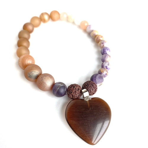 Creamy Agates, Opal Pinks and rich Purple Jaspers surround two diffuser beads and a large brown glass heart charm. Silver accent. Apply 1-2 drops of your favorite essential oil or oils. Breathe and let your heart be filled with gratitude.  Type: Diffuser Bracelet Size: 7