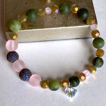 Load image into Gallery viewer, Diffuser bracelet that sparkles with its Swarovski charm and iridescent lava beads to diffuse your favorite scent. Combined with Yellow Howlite (which is really shades of green) and pink glass beads, make this your wow! bracelet. Type: Diffuser Stretch Bracelet Size: 6 1/2 Bead Sizes: 4mm, 8mm