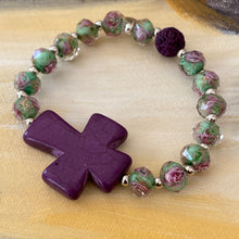 Load image into Gallery viewer, Bold Purple Cross is focal of this essential oil bracelet, surrounded by glass beads in translucent green and purple roses, purple lava bead
