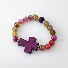 Load image into Gallery viewer, Beaded bracelet in hues of green to purple with a large purple cross as the focal
