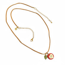 Load image into Gallery viewer, Red Apple Core and Solitary Leaf Pendant Hang from gold nylon cord and gold chain
